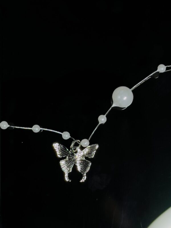 Butterfly entangled in pearl Chain